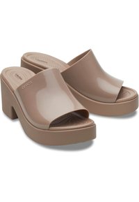 Sandales à plateforme beige clair avec surface lisse et brillante, design à bout ouvert et semelle intérieure rembourrée. Dotées d'un talon bloc pour plus de stabilité.