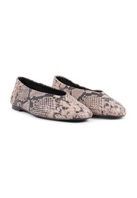 Zapatos planos en un patrón de estampado de serpiente en beige y negro, superficie texturizada, punta redonda y bajo perfil con un acabado mate sutil.