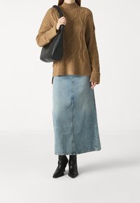 Ruskean värinen cable-knit neulepaita, vaaleansiniset farkku-maxihameet, musta nahkalaukku ja mustat nilkkurit. Neulepaidan korkea kaulus ja ribattu pinta.