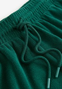 Grønne shorts med snøre i en struktureret stofkvalitet, der har en flettet snor og metalender. Blød, afslappet og let design.