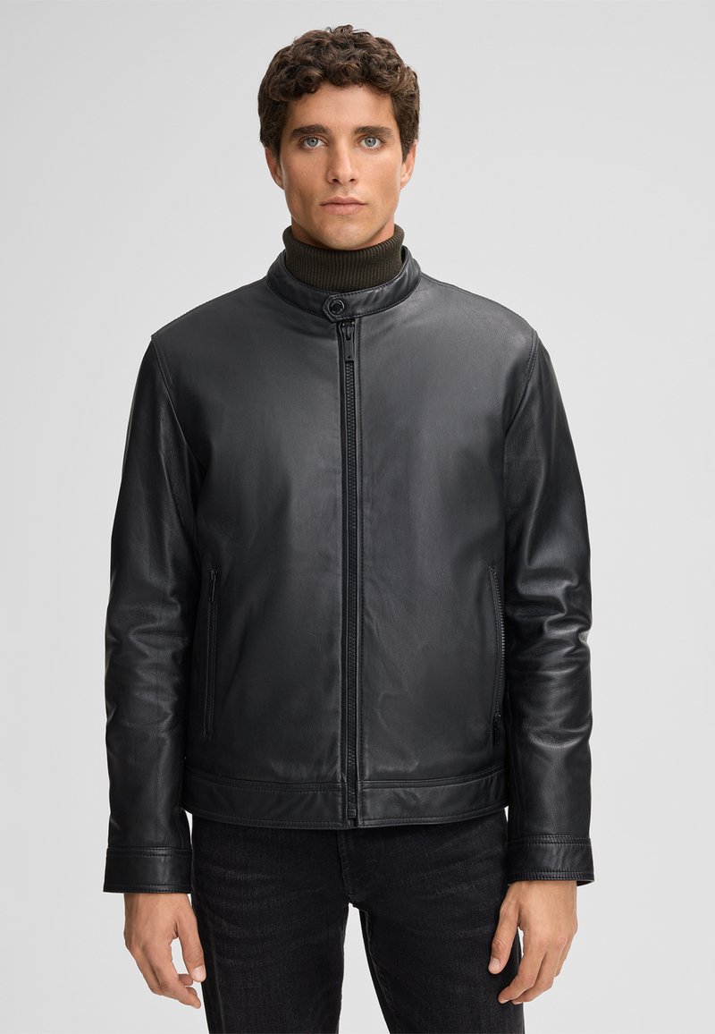 Giacca in pelle nera con colletto rialzato, chiusura frontale con zip e tasche laterali. Presenta una texture liscia e una vestibilità aderente.