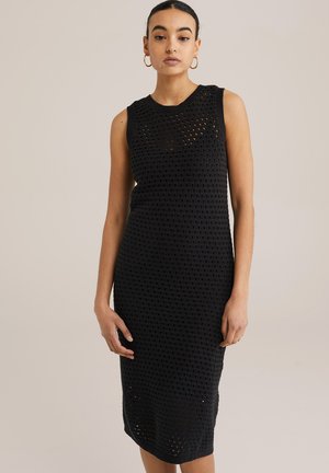 Abito nero lavorato a maglia con design senza maniche, caratterizzato da un motivo a trama aperta testurizzata e una silhouette fino al ginocchio.