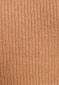 Tissu tricoté de couleur pêche clair avec une texture côtelée. Comprend des fils brillants subtils entrelacés pour plus de détail.