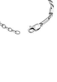 Srebrna bransoletka łańcuszkowa z ogniwami połączonymi ze sobą, z zapięciem na karabińczyk i gładkim wykończeniem. Oznaczona napisem "BREIL" na zapięciu.
