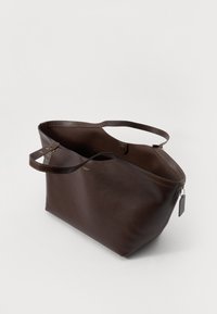 Borsa a tracolla in pelle marrone con due manici, apertura superiore e zip dorata. Caratterizzata da una texture liscia e dettagli di cucitura. L'interno è spazioso.