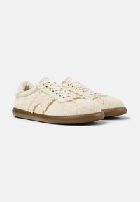 Sneaker in tessuto bianco intrecciato con superficie testurizzata, punta rotonda e suola in gomma marrone; presenta lacci e bordi sfilacciati.