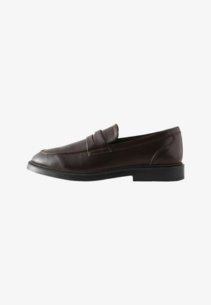 Ciemnobrązowy skórzany mokasyn z czarną podeszwą, styl slip-on, z detalem w postaci paska na cholewce.