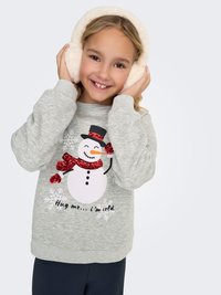 Grijze trui met opdruk van een sneeuwpop, rode glinsterende sjaal en tekst. Model draagt pluche witte oorkappen, lacht met handen op de oren.