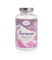 Clear glass jar with a silver lid containing white milk bath powder. Label features lavender and pink floral designs, reads "Harmonie."