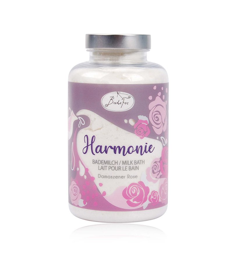Clear glass jar with a silver lid containing white milk bath powder. Label features lavender and pink floral designs, reads "Harmonie."