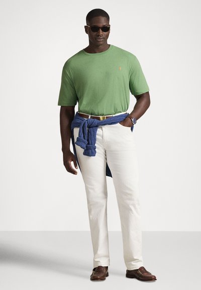 Πράσινο βαμβακερό μπλουζάκι, λευκό παντελόνι λινό, μπλε πουλόβερ δεμένο στη μέση, καφέ μοκασίνια και γυαλιά ηλίου. Απλή, καθημερινή ενδυμασία.