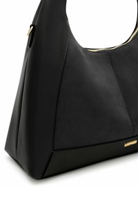 Borsa nera realizzata con una combinazione di pelle liscia e suede testurizzato. Design angolare con zip dorata e dettaglio di branding sottile.