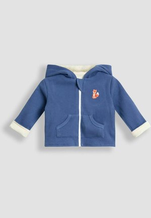 Blauwe geribbelde hoodie met crèmekleurige boorden, zakken aan de voorkant en een geborduurd vosdetail op de linkerborst. Ritssluiting, zachte binnenvoering.