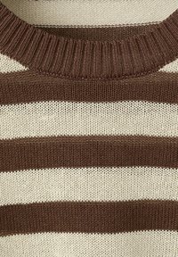 Primo piano della scollatura e della parte superiore del petto di un maglione lavorato a maglia con righe orizzontali marroni e bianche.