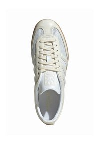 Balti sporta apavi ar aizsargājošu un ādas augšdaļu, bēšiem šņorēm, trim svītrām sānos un teksturētu gumijas zoli.