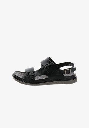 Sandale noire à bout ouvert avec des brides réglables, une semelle texturée et une fermeture à boucle autour du talon.