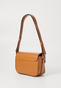 Sac bandoulière en cuir marron avec une texture lisse, rabat pliable et bandoulière ajustable. Présente des accessoires en doré et des détails de couture blanche.