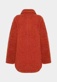 Orange fleecejacka med krage, långa ärmar och en mjuk, texterad finish. Rundad nederkant bak, designad för värme och komfort.