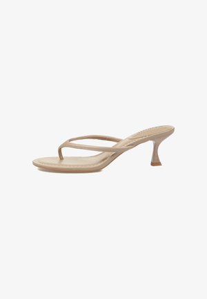 Sandalia beige de cuero con tacón, tiras finas y un tacón estrecho y curvado, mostrada de lado sobre un fondo blanco.