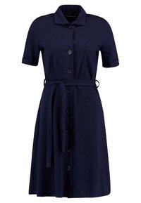 Námořnický modrý šatyhem bavlněným ve hladkém provedení, s krátkými ohrnutými rukávy, knoflíkovým zapínáním vpředu, dvěma postranními kapsami a páskem na zavázání v oblasti pasu.