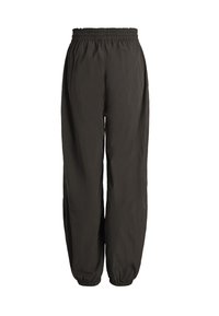 Schwarze locker sitzende Hose mit elastischem Bund und elastischen Bündchen, hergestellt aus leichtem Stoff, vor weißem Hintergrund dargestellt.