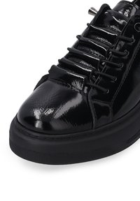 Černé lakované kožené tenisky s kulatou špičkou, plochými tkaničkami a strukturovanou gumovou podrážkou. Obsahují kovové průchody pro tkaničky a elegantní designové linie.