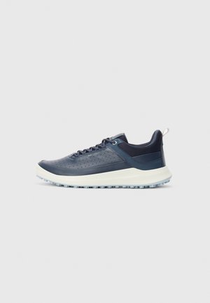 Navy blue low-top sneaker with perforated leather upper, white sole, cushioned collar, lace-up closure, and textured outsole for grip.
