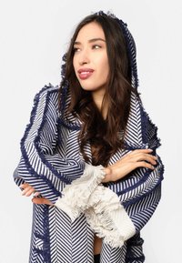 Blauw-witte gestreepte sjaal met een franjerand en capuchon, met een textuurstof en een geometrisch patroon.