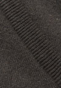 Brązowa wełniana tkanina o teksturowanym wzorze dzianiny. Zawiera ribbedowe akcenty oraz gładką sekcję, ukazującą połączenie miękkich i szorstkich włókien.