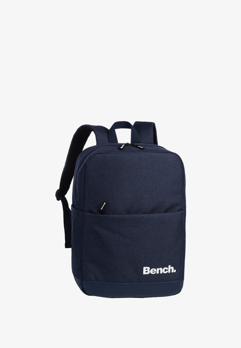 Sac à dos Bench bleu marine avec bretelles rembourrées, poche avant zippée et poignée de transport supérieure sur fond blanc.