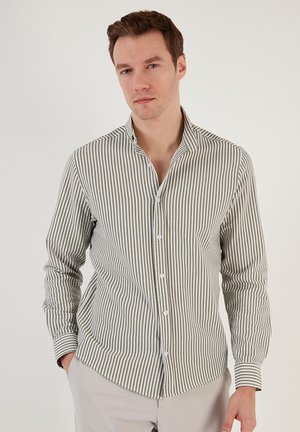 Chemise à rayures verte et blanche. Comprend un col, des manches longues et un design ajusté avec une texture subtile.