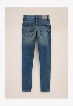 Kék farmernadrág kopott mosással, öt zsebes kialakítással, téglalap alakú hátsó zsebekkel és bőr címkével a deréknál.