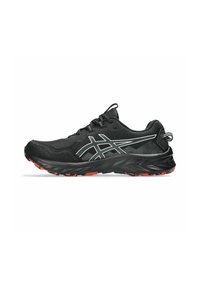 Zapatilla de running negra con parte superior de malla texturizada, acentos reflectantes en blanco y suela de goma negra y roja con patrón. Diseñada para el rendimiento.