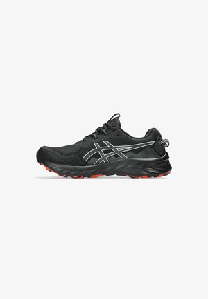 Chaussure de course noire avec une tige en mesh texturé, des accents réfléchissants blancs et une semelle en caoutchouc noire et rouge à motif. Conçue pour la performance.