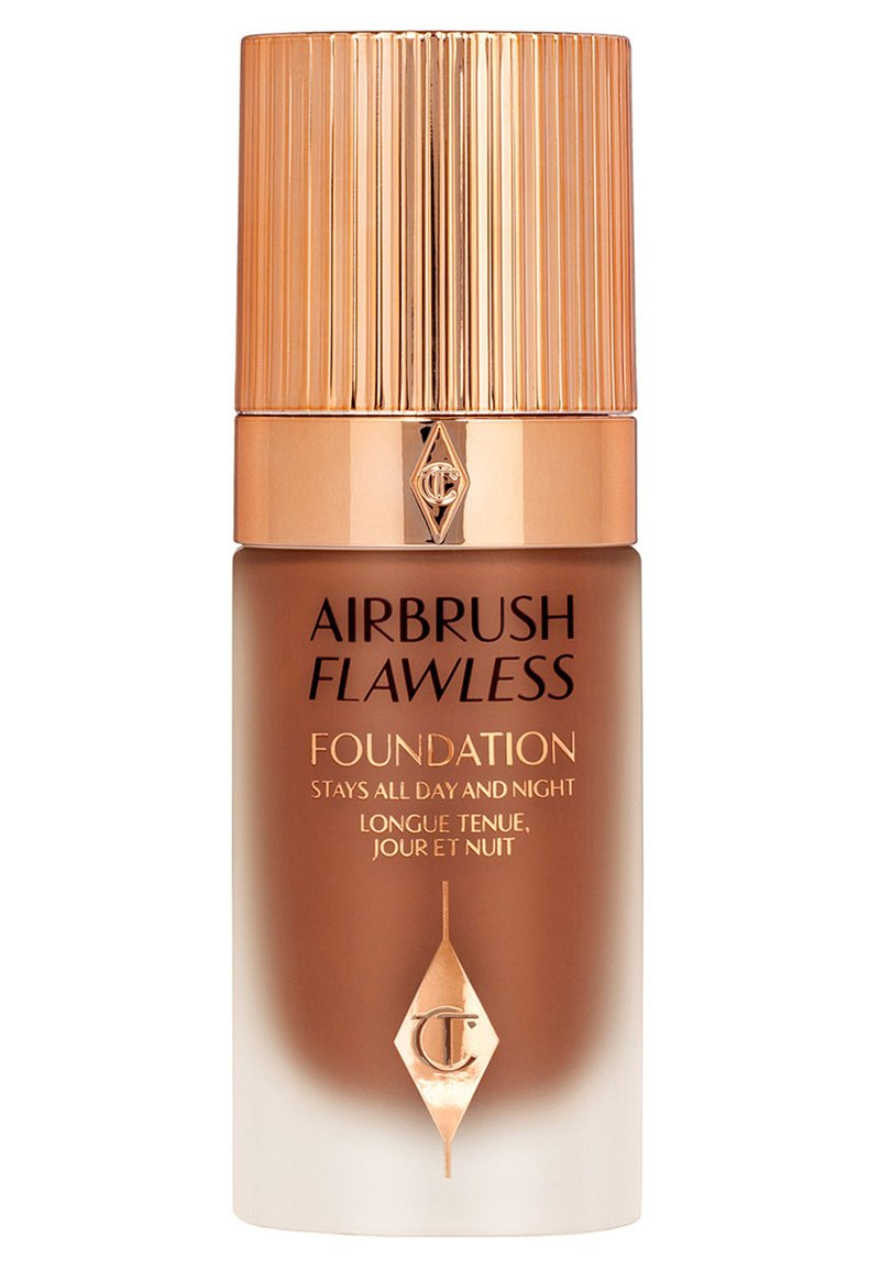 Foundation bottle with a gold ribbed cap, featuring a brown gradient glass body, and labels in gold text stating "Airbrush Flawless Foundation."