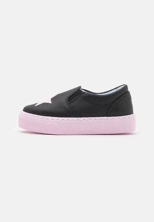Zapato negro de tipo slip-on con suela rosa, que presenta una gran estrella rosa en la puntera. Hecho de cuero suave con una suela de goma texturizada.