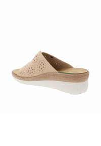 Sandale beige à enfiler avec un design supérieur perforé, semelle intercalaire similaire au liège et semelle extérieure en caoutchouc blanc. Semelle intérieure rembourrée pour le confort.