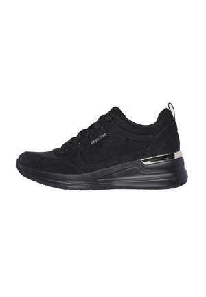 Zapatillas deportivas negras con parte superior de ante, diseño de cordones y un acento metálico en el talón. Punta redondeada con suela acolchada.