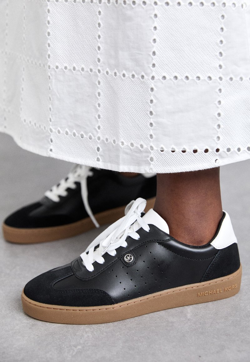 Zwarte leren en suède sneakers met witte veters, gumrubberen zool en geperforeerde details. Witte hakkap met reliëf merklogo.