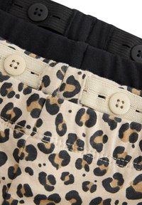 Ceinture à imprimé léopard en beige et noir, dotée de deux boutons et de détails élastiques, avec une texture lisse et une couture visible.