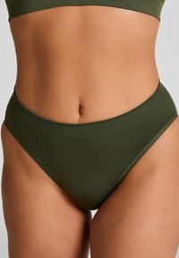 Donkergroene katoenen highwaisted slips met een gladde textuur en een geribde tailleband, met een eenvoudig en minimalistisch ontwerp.