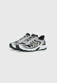 Pair of black and silver Skechers sport sneakers with white soles on a plain light background.