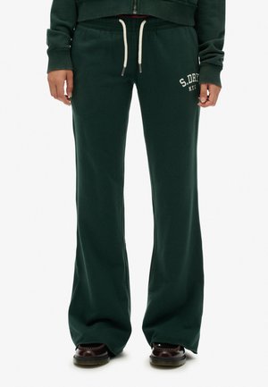 Pantalons de jogging évasés vert foncé avec taille à cordon, comportant un texte de logo blanc sur la hanche gauche et une texture de tissu douce et lisse.