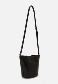 Svart läder bucket bag med en texturerad krokodilmönster, smal justerbar rem och detaljer i guldton.