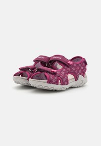 Sandalias rosas con cintas de velcro, patrón floral en la parte superior, suela gris con textura antideslizante. Diseño abierto para mayor transpirabilidad.