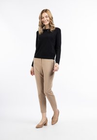 Maglione nero a maniche lunghe, pantaloni beige su misura e scarpe con tacco a blocco color nude. Tessuto dalla texture liscia e design slim-fit con una silhouette pulita.