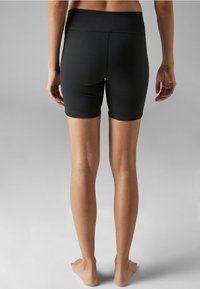 Sorte atletiske shorts lavet af strækstof, med høj talje og længde til midten af låret, med en glat overflade og ingen synlige mønstre.
