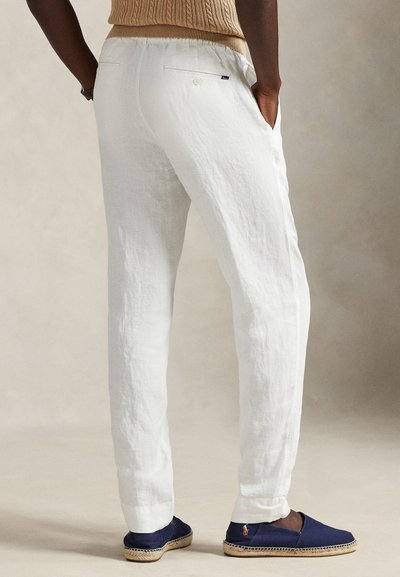 Λευκό λινό παντελόνι με χαλαρή εφαρμογή, διαθέτει πλαϊνές τσέπες και πίσω τσέπη με κούμπωμα με κουμπί. Συνδυάζεται με μπλε ναυτικό εσπαντρίγιες.