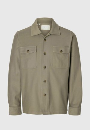 Khaki overhemd met lange mouwen en knopen, voorzien van twee voorzakken met knopen en een brede kraag.