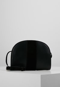 Borsa a spalla in pelle nera con finitura liscia e una striscia centrale in suede. Forma arrotondata, tracolla regolabile e design minimalista.